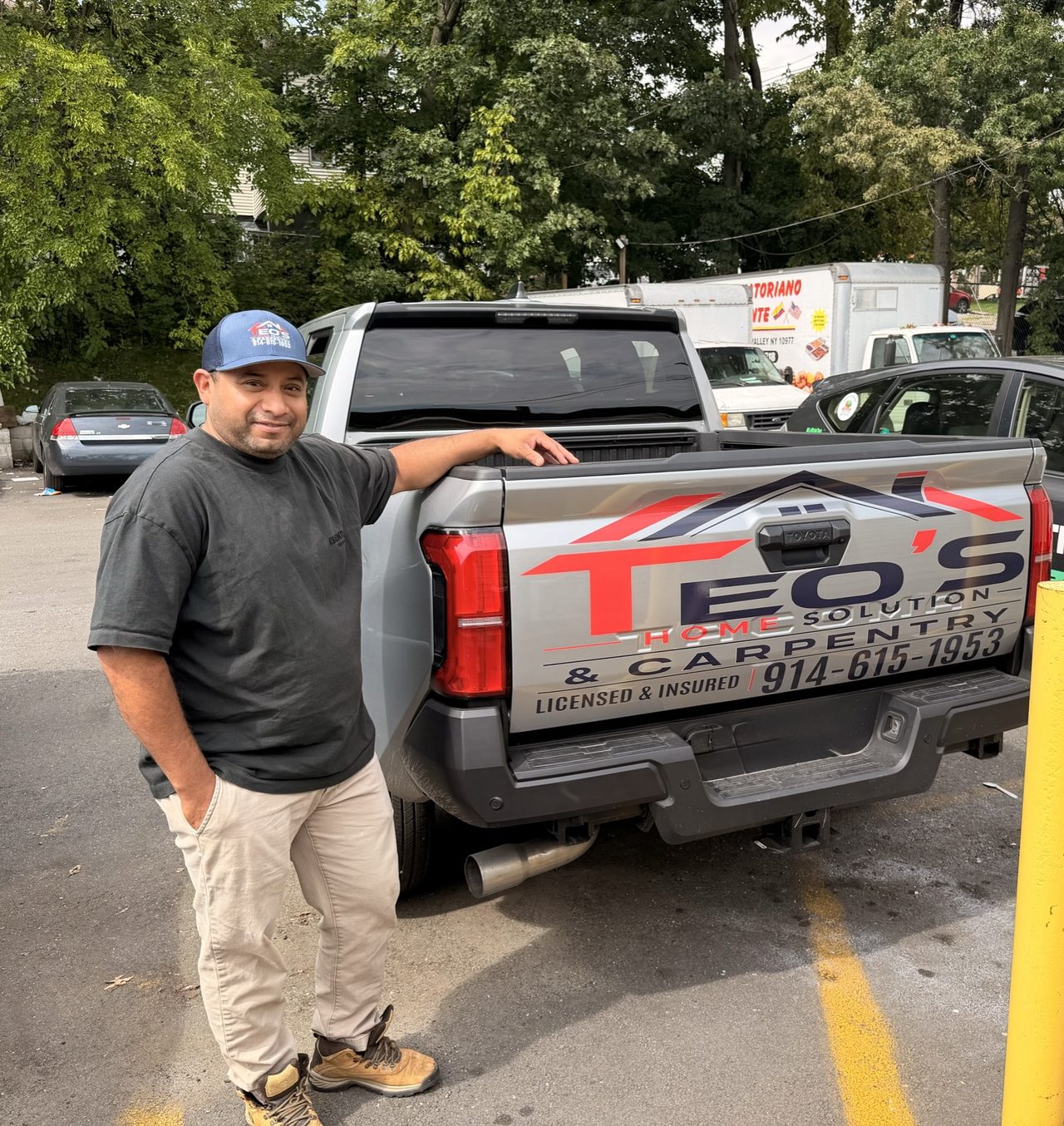 Teo’s Home Solution & Carpentry lettering on a Toyota truck tailgate beside a man
